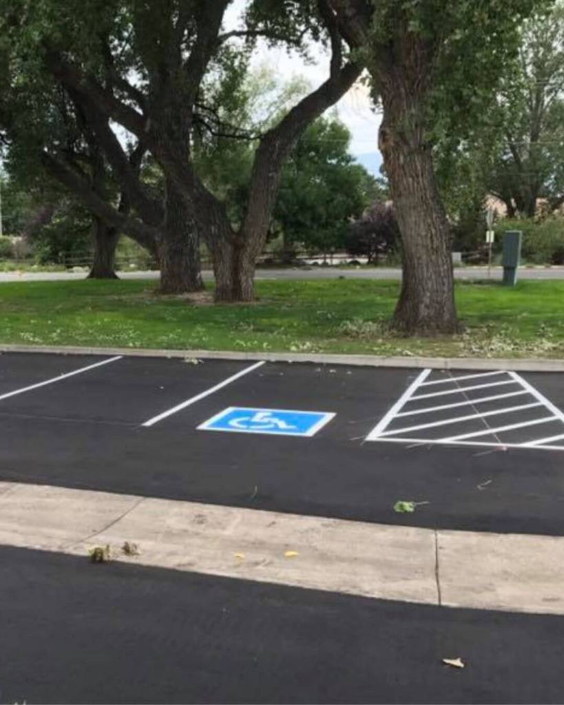 Freshly paved 2-inch hot mix asphalt overlay with ADA accessible parking stall and cross-hatched access aisle at Robison Associates dental office in Colorado Springs by Dawley Asphalt