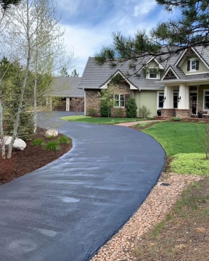 Hand applied seal coat on curved driveway at High Forest Colorado Springs craftsman home for a 25 year Dawley Asphalt client with aspen and pine landscaping