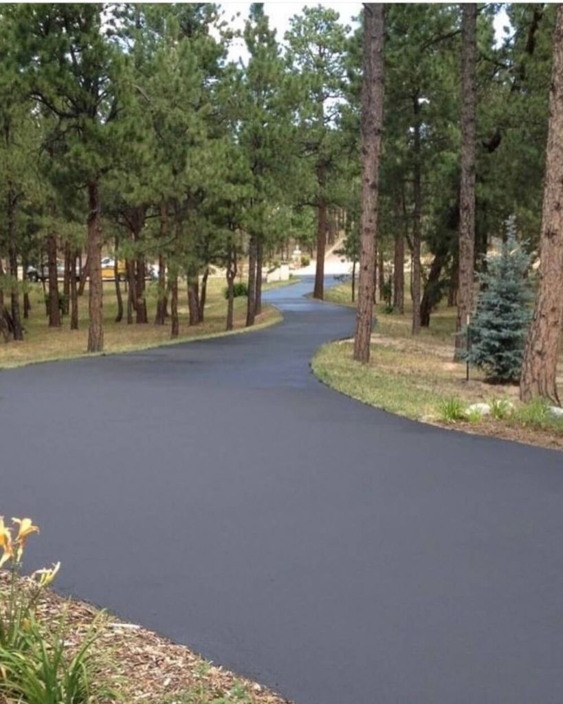 Hand applied seal coat on long winding private driveway through ponderosa pine forest in High Forest Ranch Colorado Springs by Dawley Asphalt