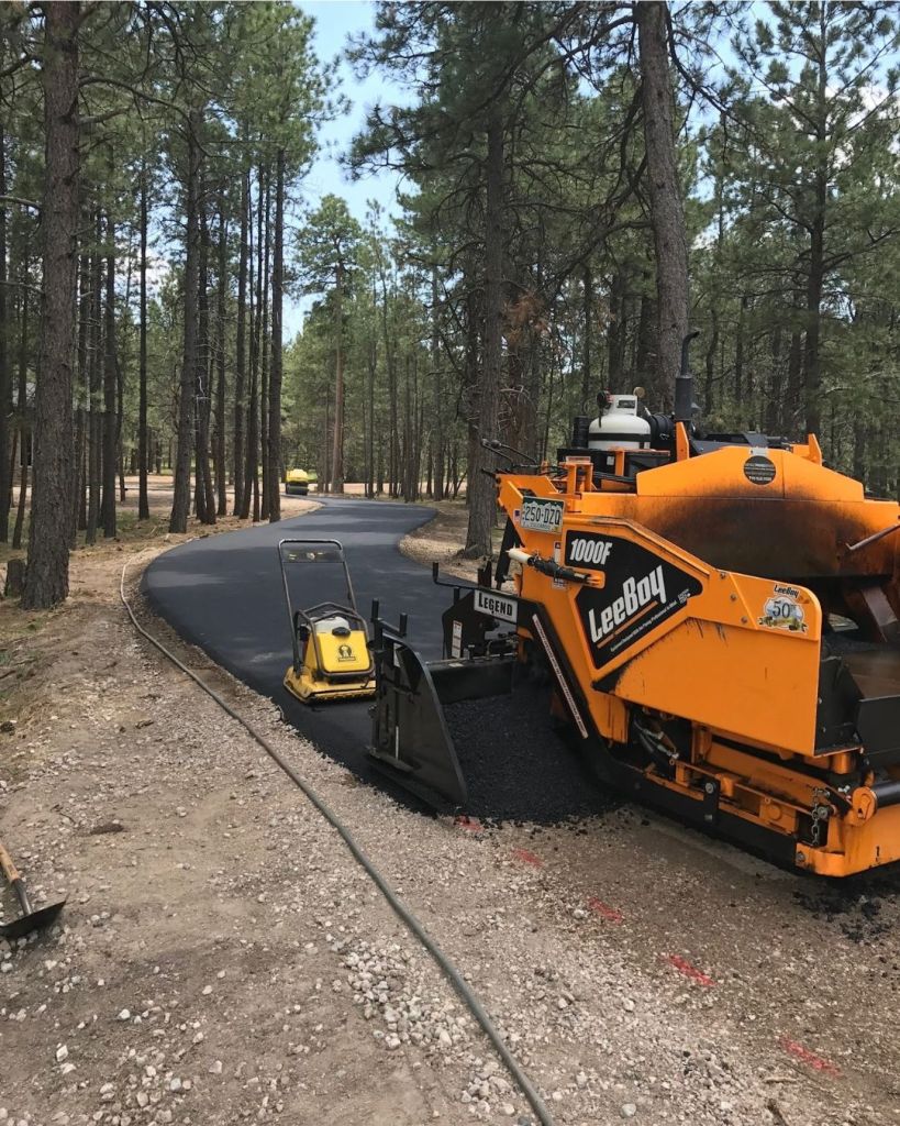 LeeBoy paver installing new 3.5 inch hot mix asphalt driveway through ponderosa pine forest in Black Forest Colorado Springs by Dawley Asphalt