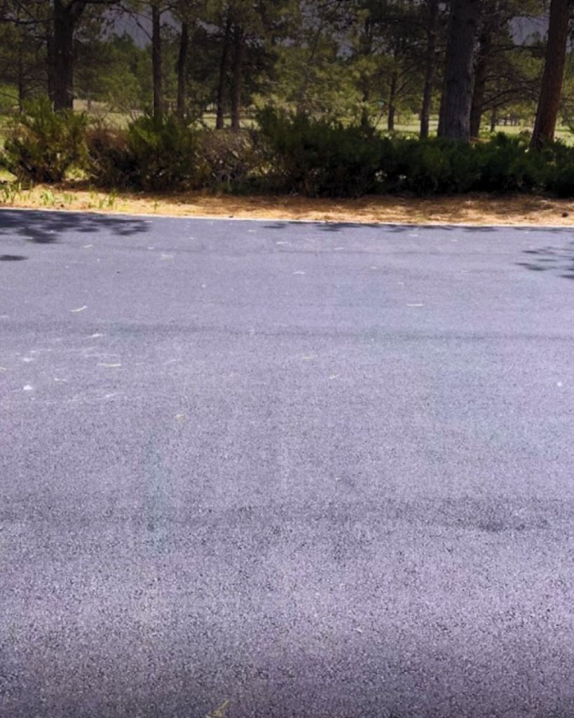 New 3.5 inch hot mix asphalt pickleball and basketball half court installation at private Monument Colorado residence with brick entry pillars and ponderosa pine backdrop by Dawley Asphalt